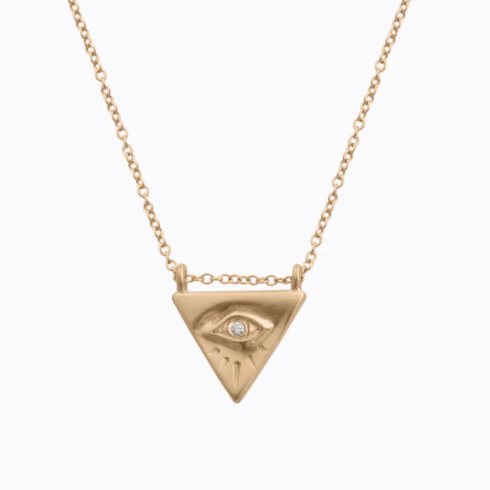 Hand-fabricated Fairmined gold triangle pendant necklace with engraved eye and diamond detail, minimalist white background