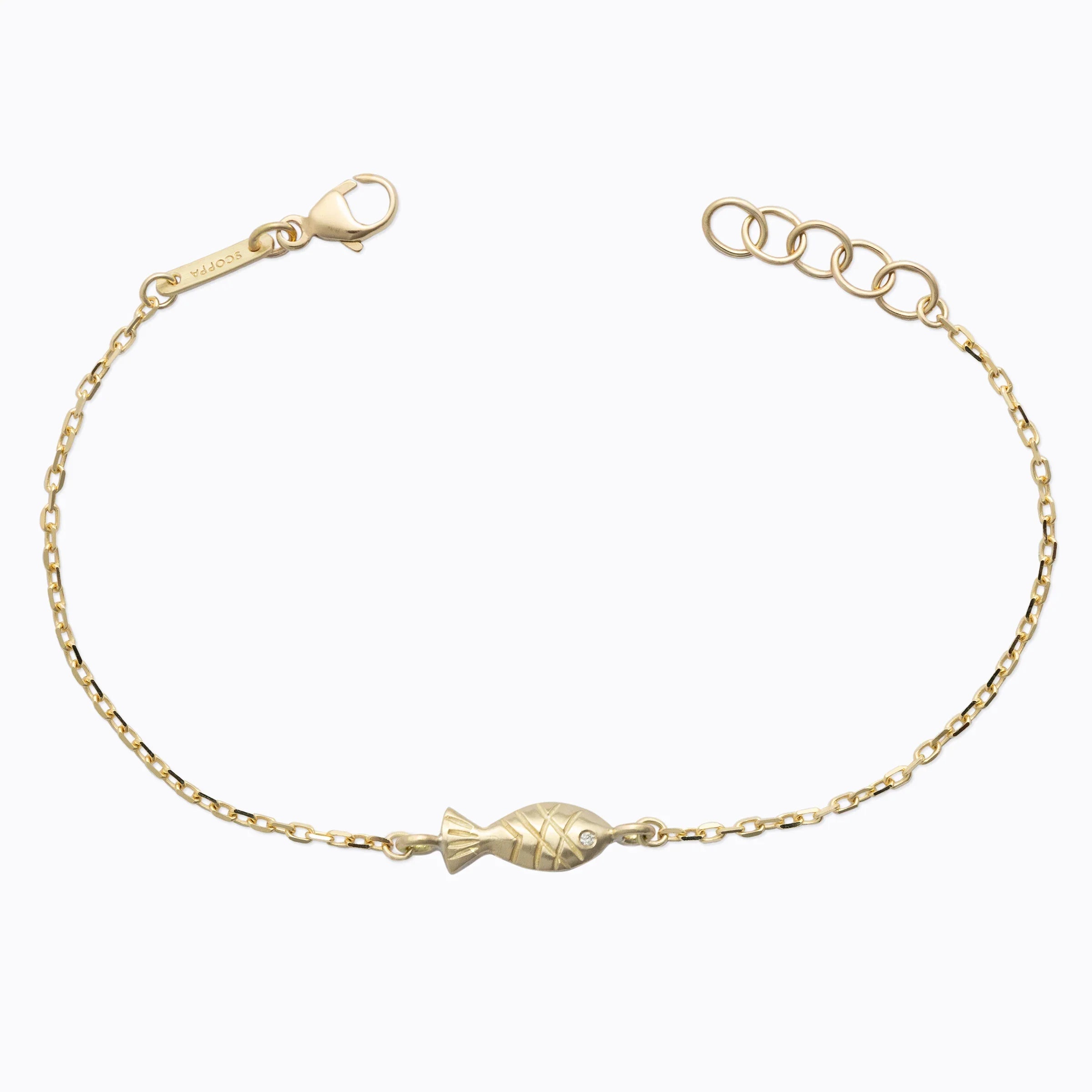 Delicate 14k gold bracelet with fish-shaped charm and tiny diamond accent on chain