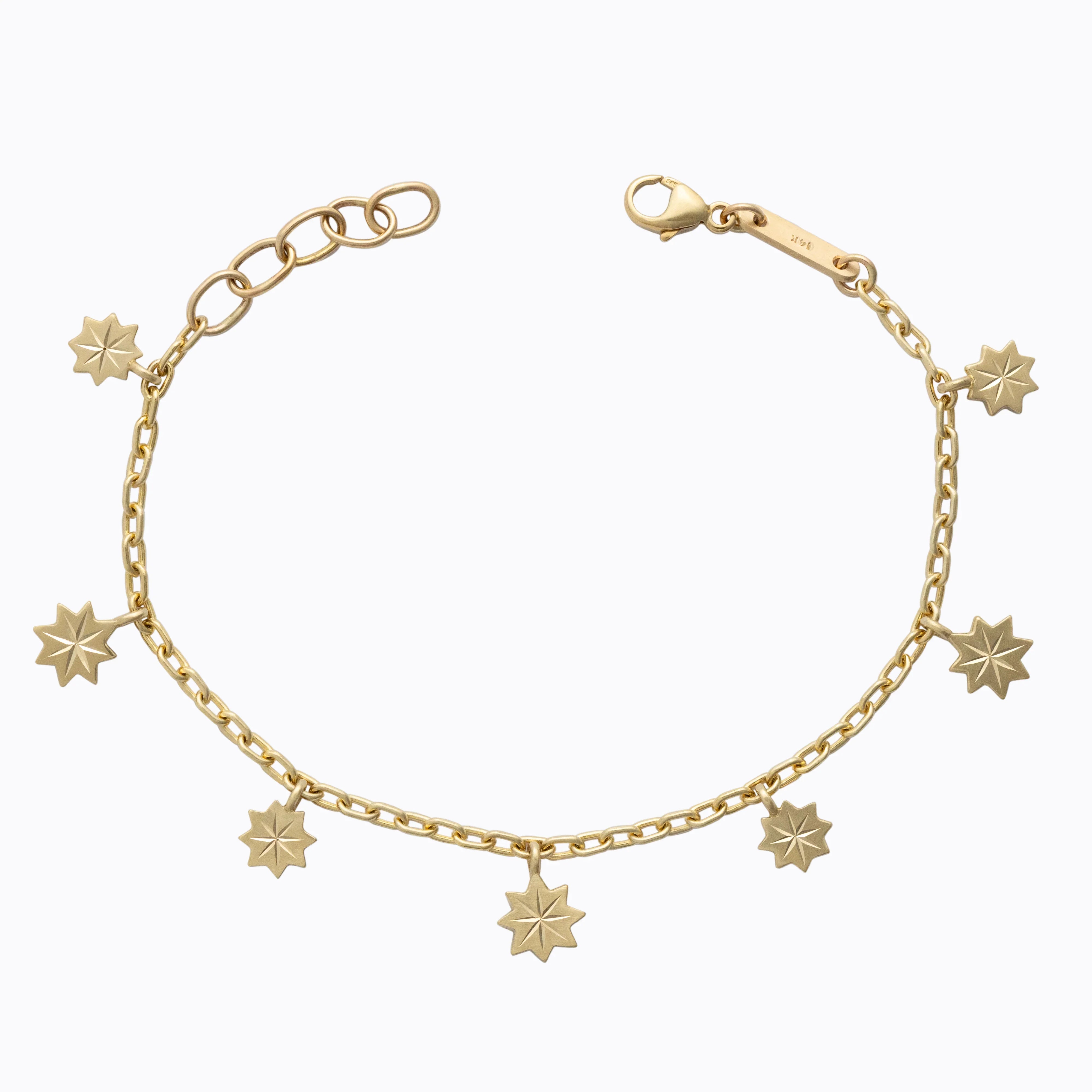 Delicate gold charm bracelet with seven star-shaped pendants on white background