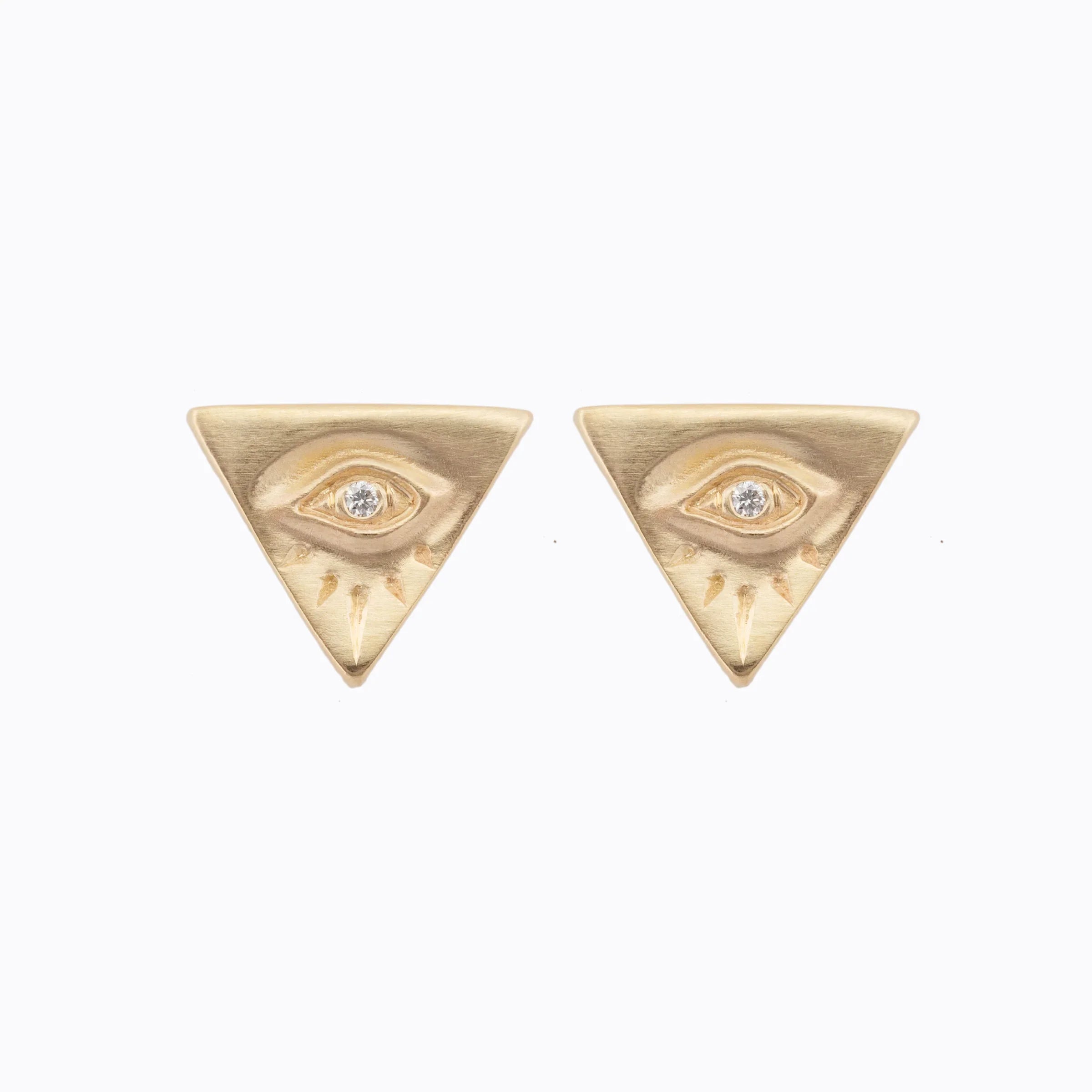 Pair of hand-engraved gold triangular earrings with eye motif and central diamond, on white background