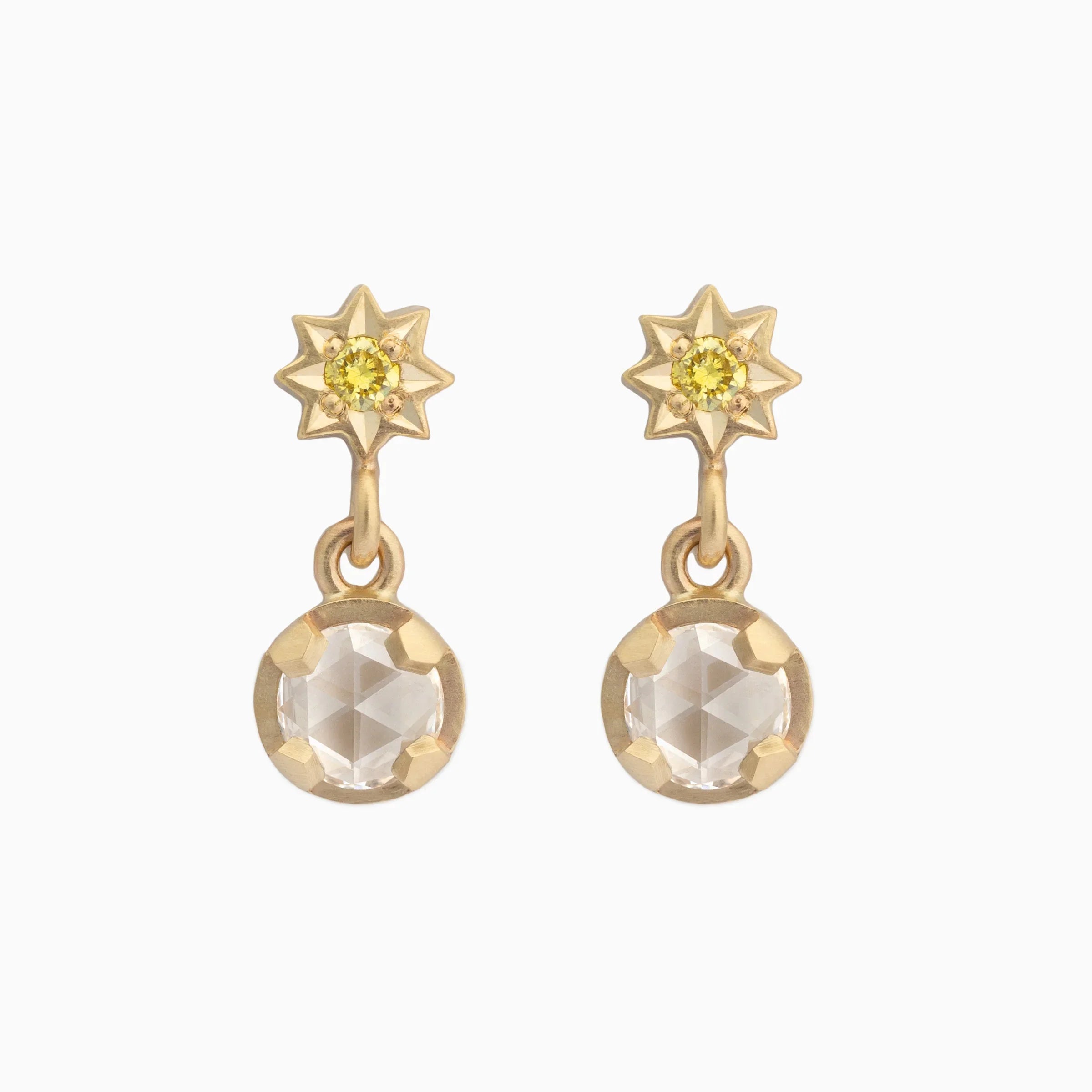 Elegant hand-fabricated gold star stud earrings with yellow gemstone and clear faceted drop on white background