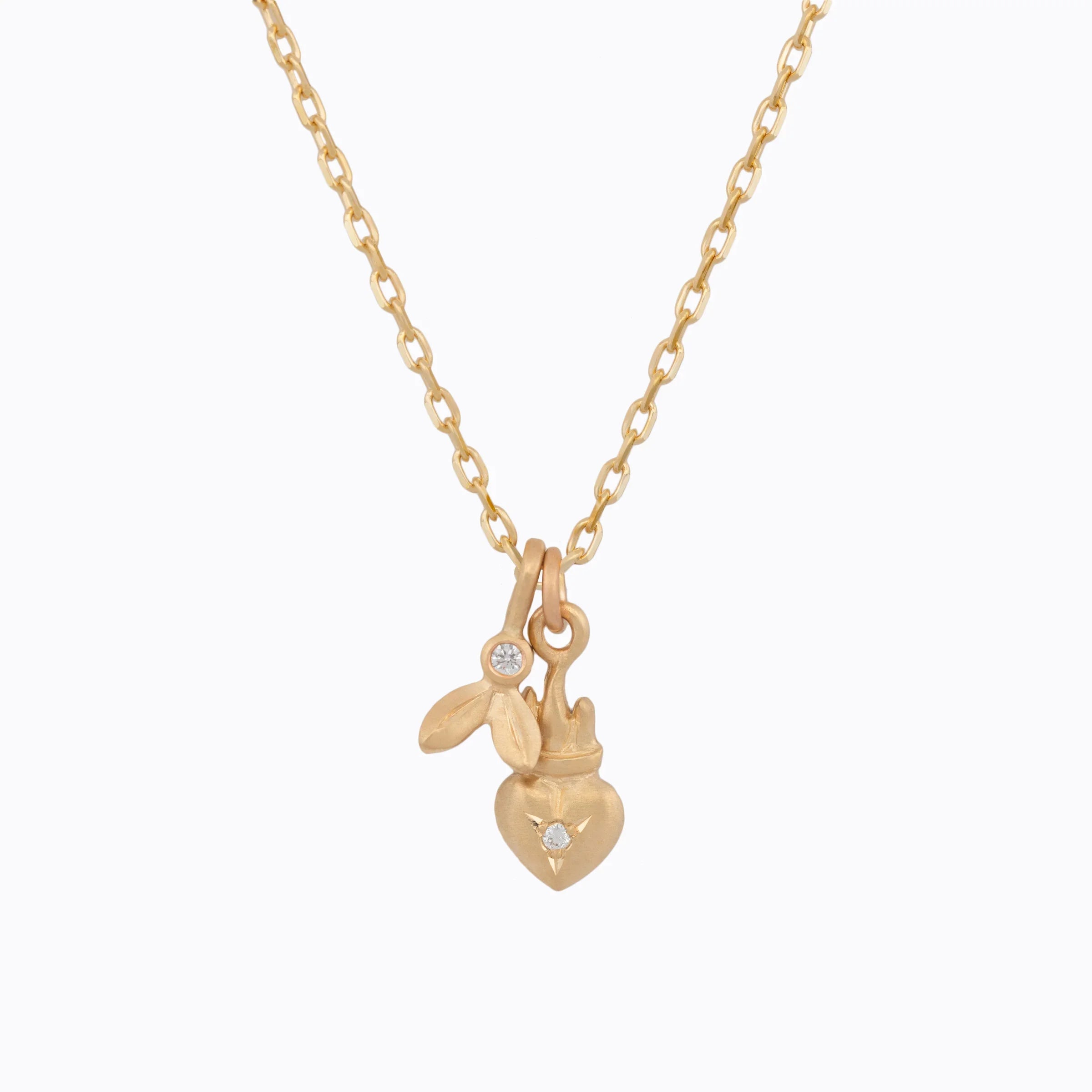 Delicate gold chain necklace with two handcrafted pendants featuring diamonds, clean white background