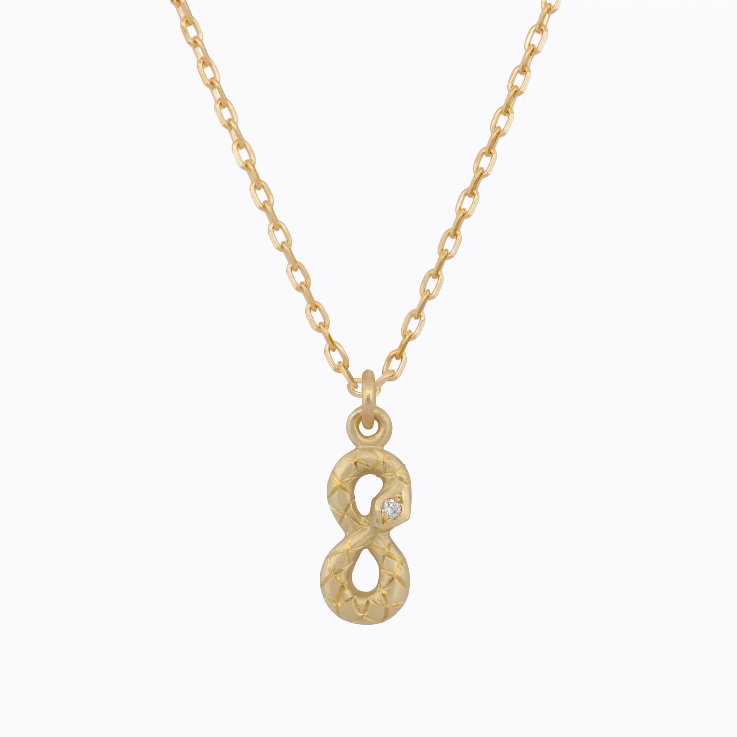 Handcrafted gold infinity pendant with subtle diamond accent on delicate chain, clear white background