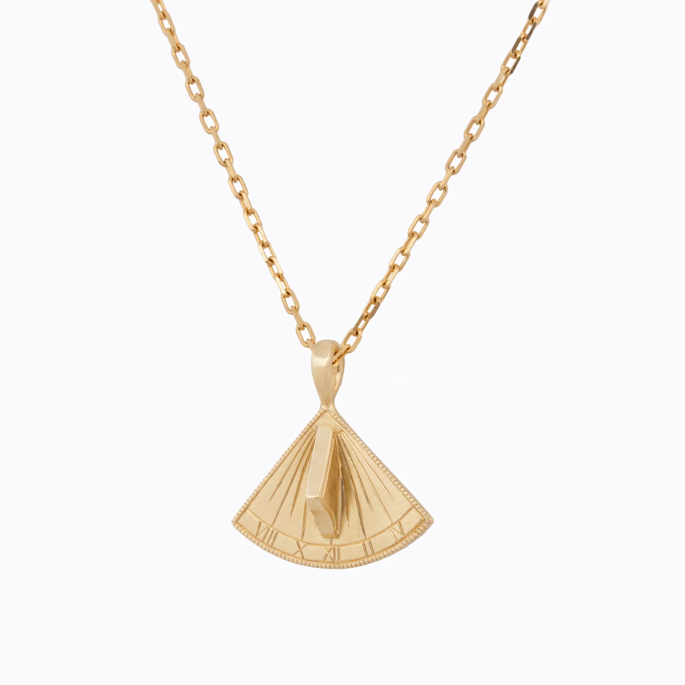 Hand-fabricated gold sundial pendant necklace with Roman numerals, photographed on white background