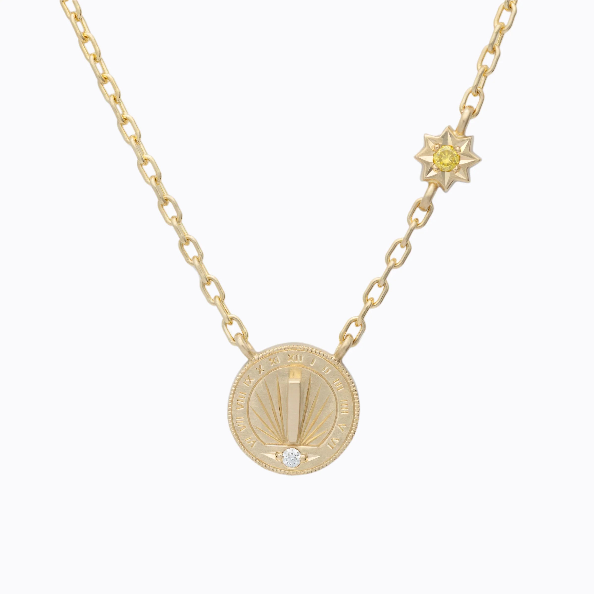 Handcrafted gold sundial pendant necklace with diamond and yellow sapphire, minimalist white background