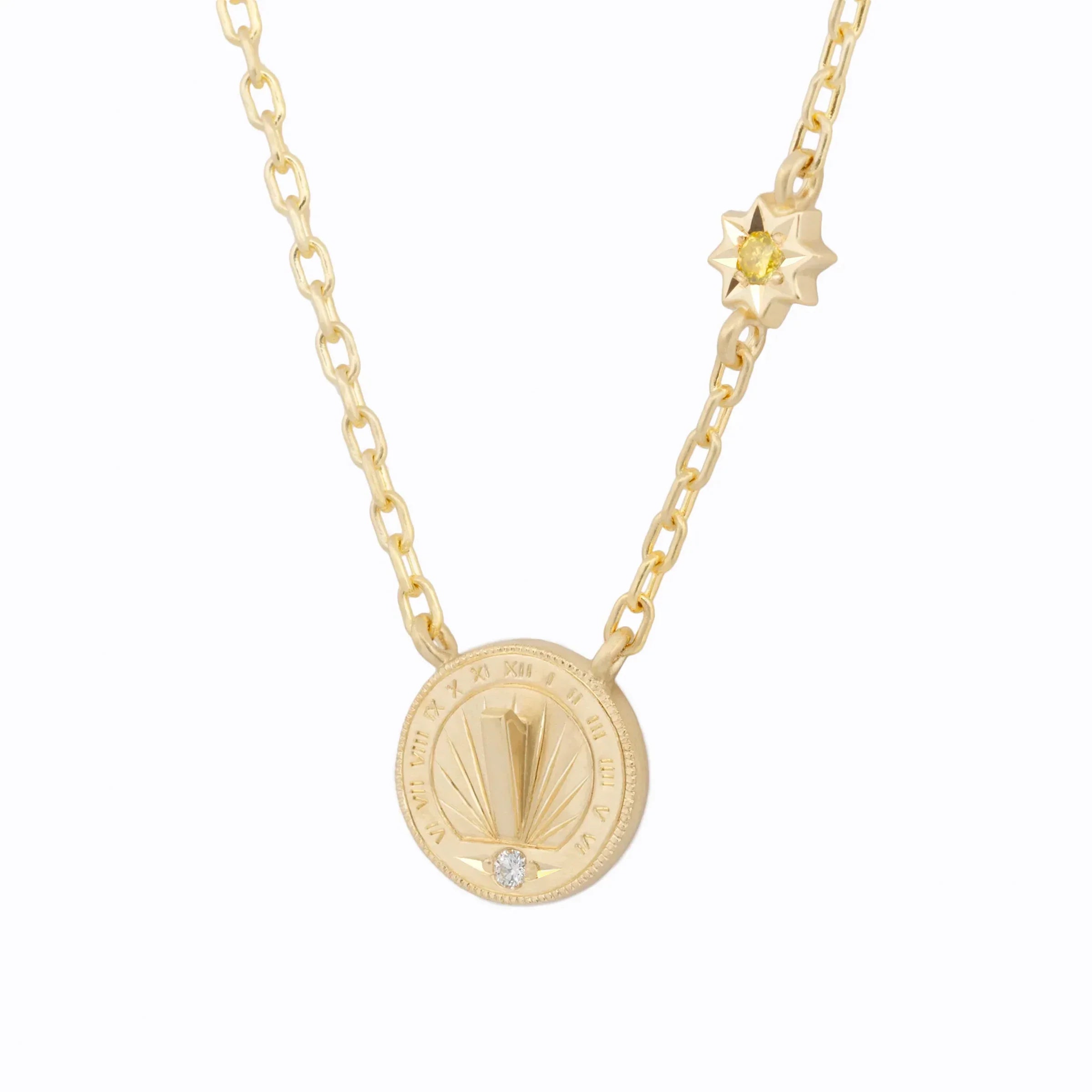 Close-up of handcrafted gold sundial pendant necklace with diamond detail and star charm on white background