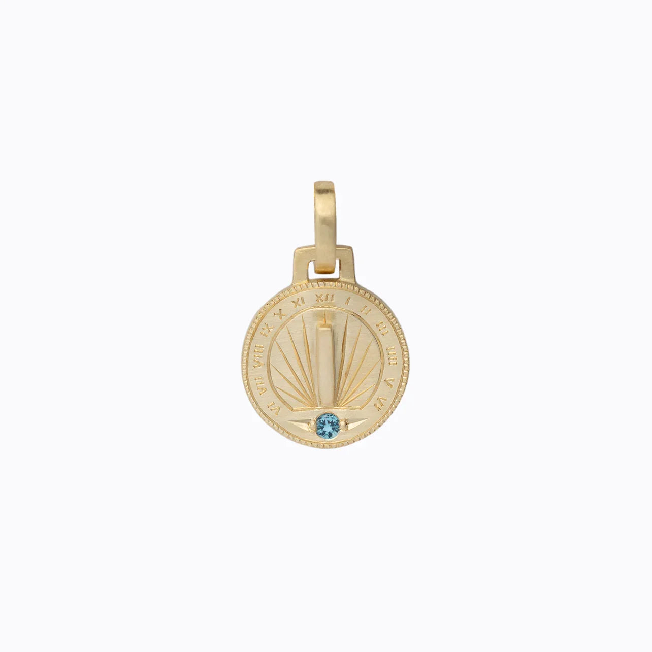 Hand-fabricated Fairmined gold sundial pendant with hand-engraved Roman numerals and blue gemstone, photographed on soft white background