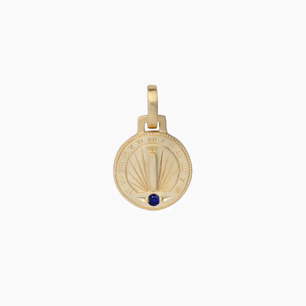Handcrafted Fairmined gold sundial pendant with Roman numerals and blue gemstone on neutral background