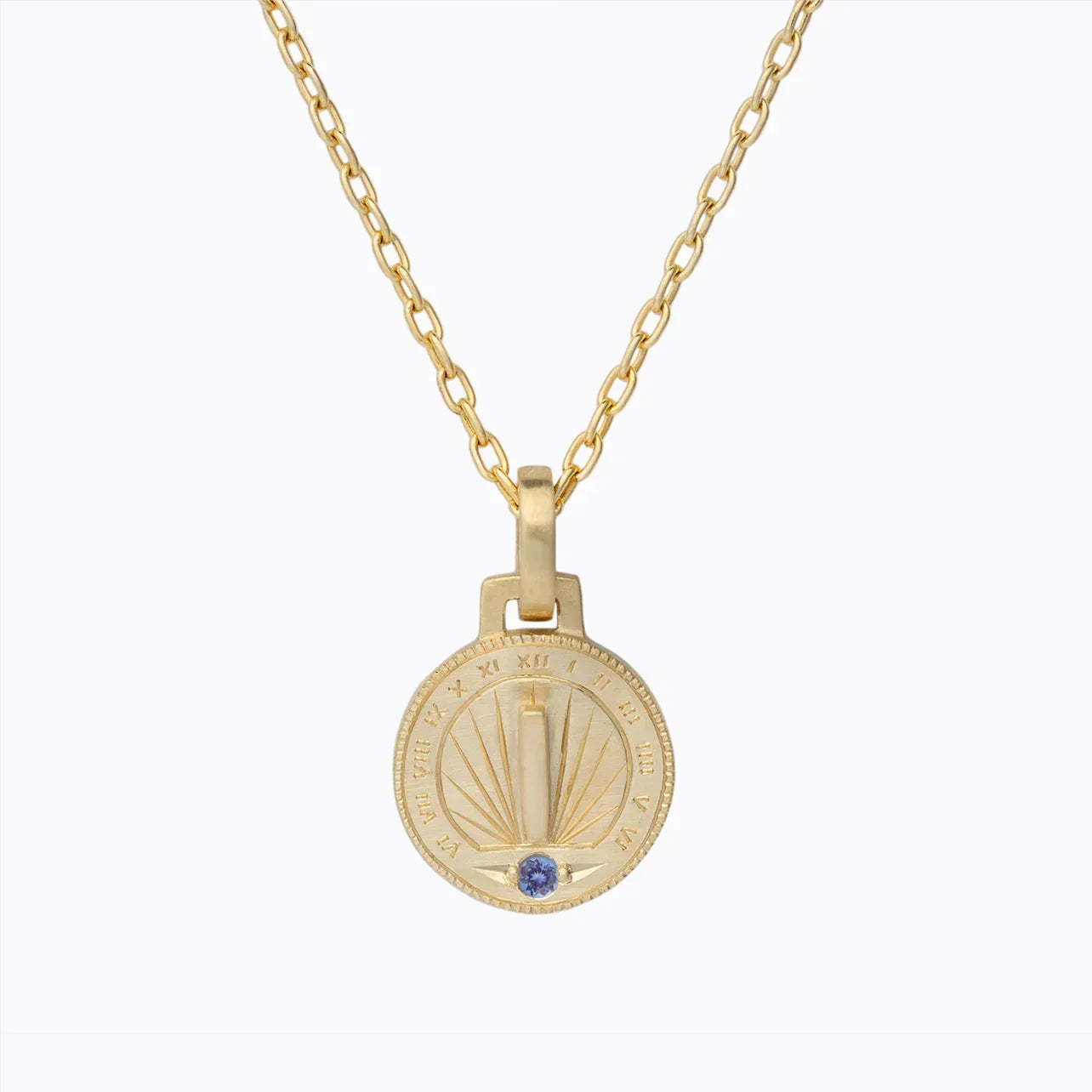 Hand-fabricated Fairmined gold sundial pendant with hand-engraved hour markers and blue gemstone on chain