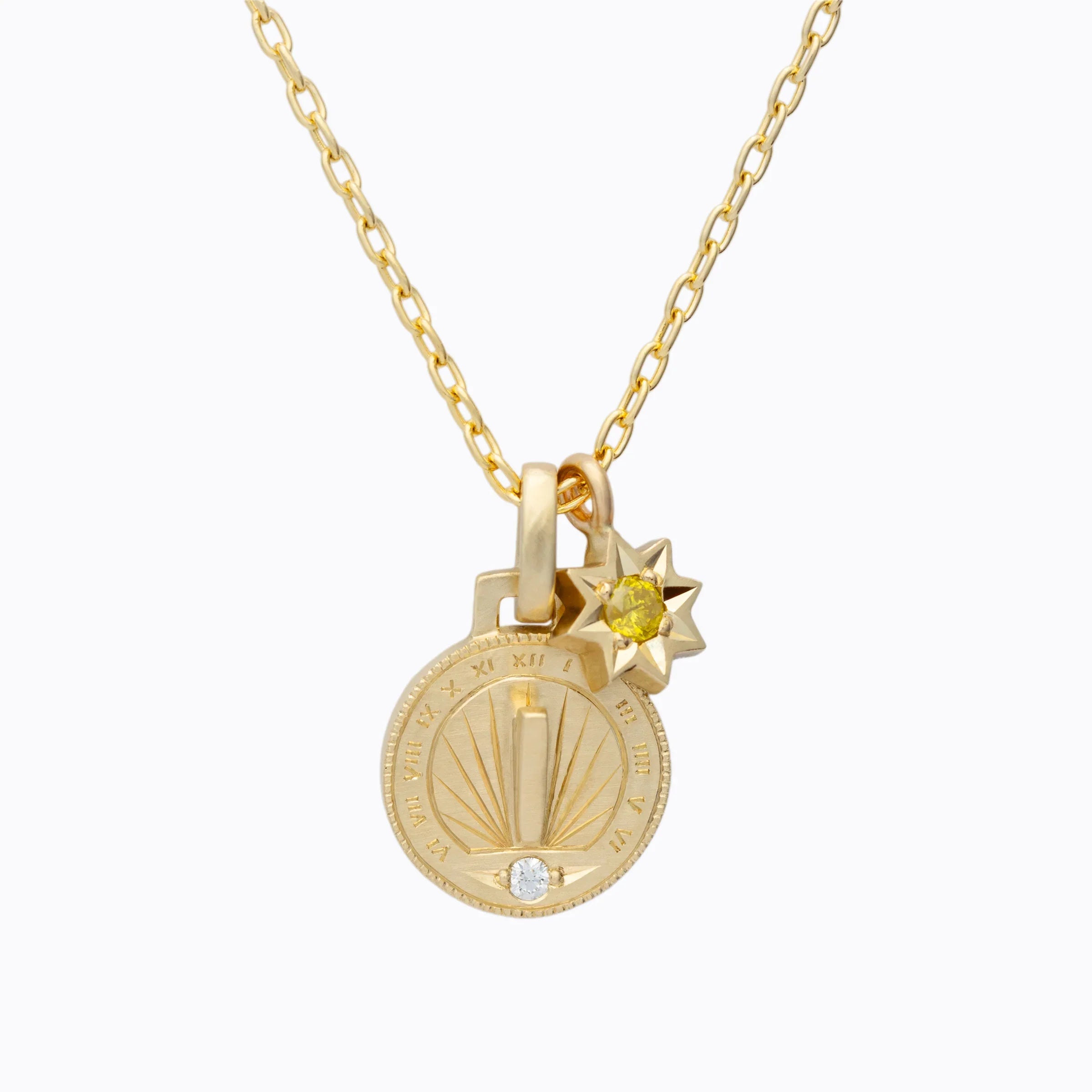 Delicate 18k gold sundial pendant with engraved Roman numerals and sun charm featuring yellow gemstone