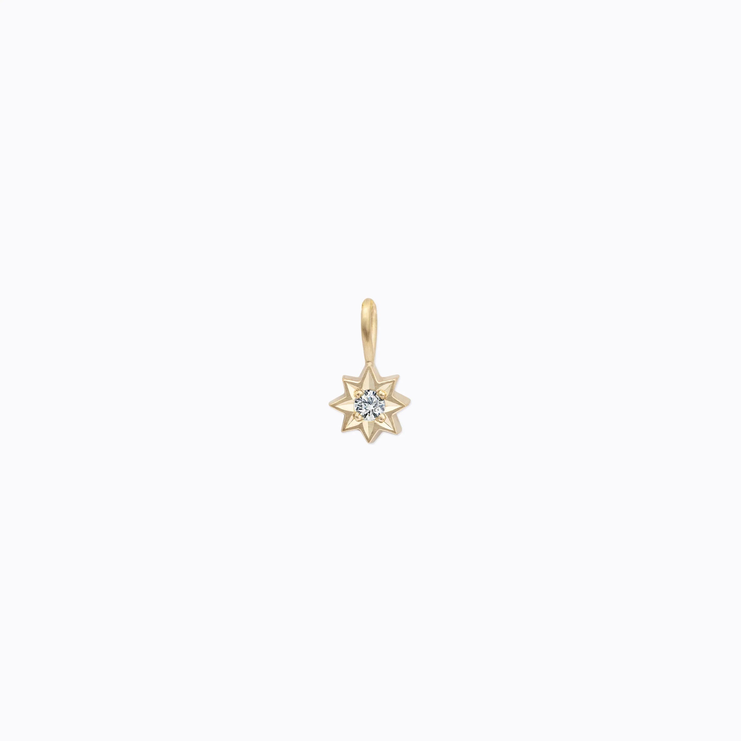 Delicate 14k yellow gold star-shaped pendant with central diamond set on clean white background