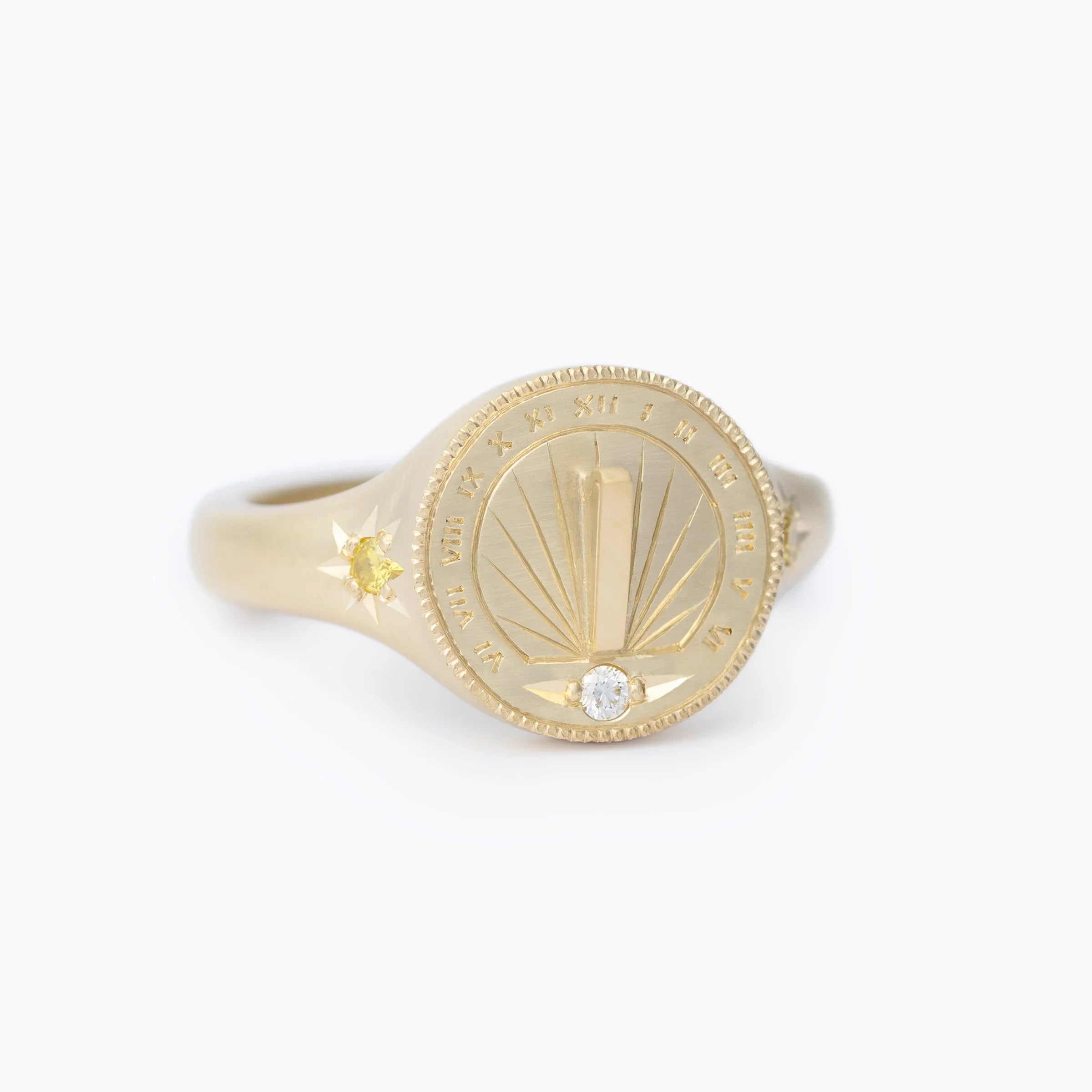 Handcrafted Fairmined gold sundial ring with hand-engraved numerals, diamond detail, on white background