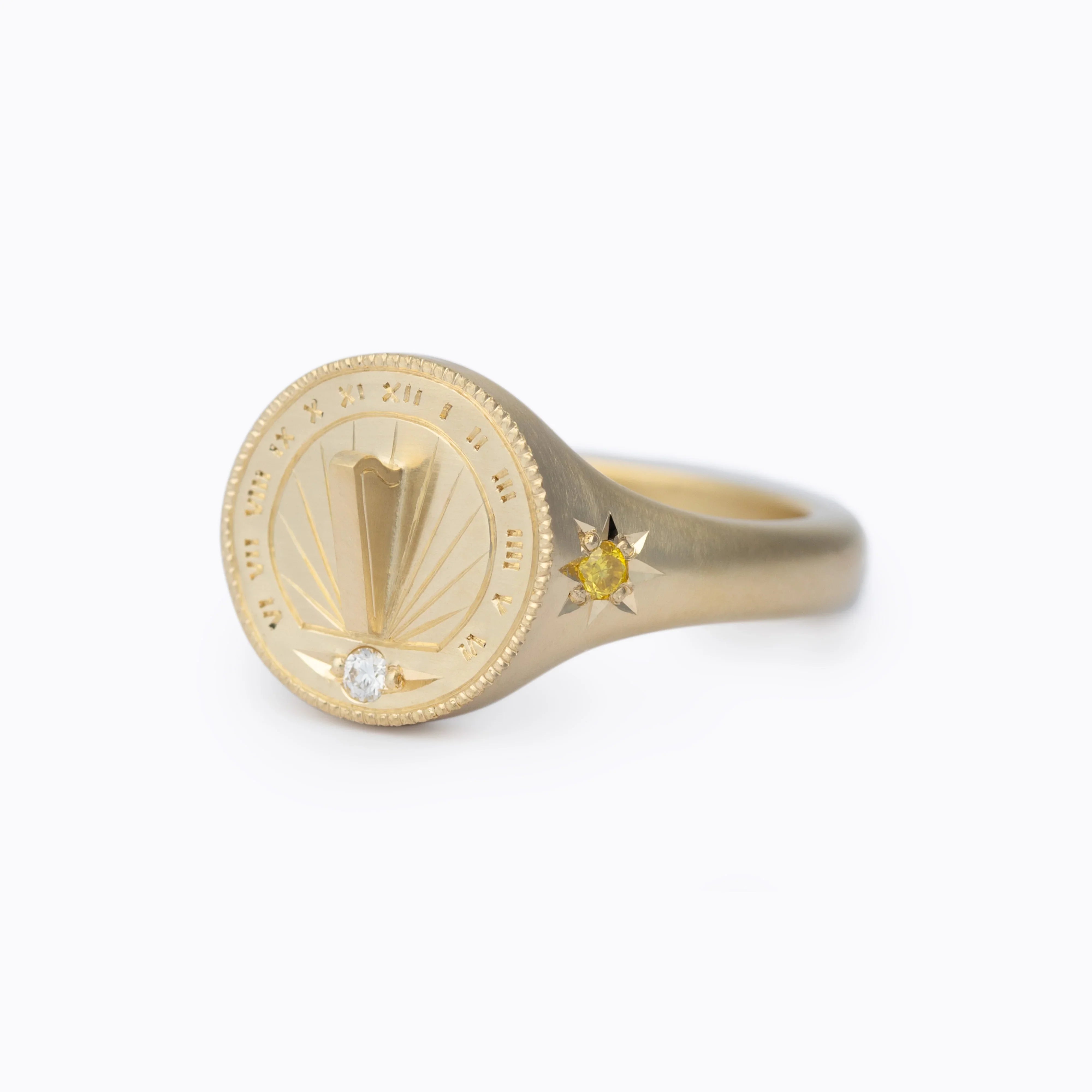 Handcrafted gold sundial ring with engraved hour markers and white diamond, warm natural light