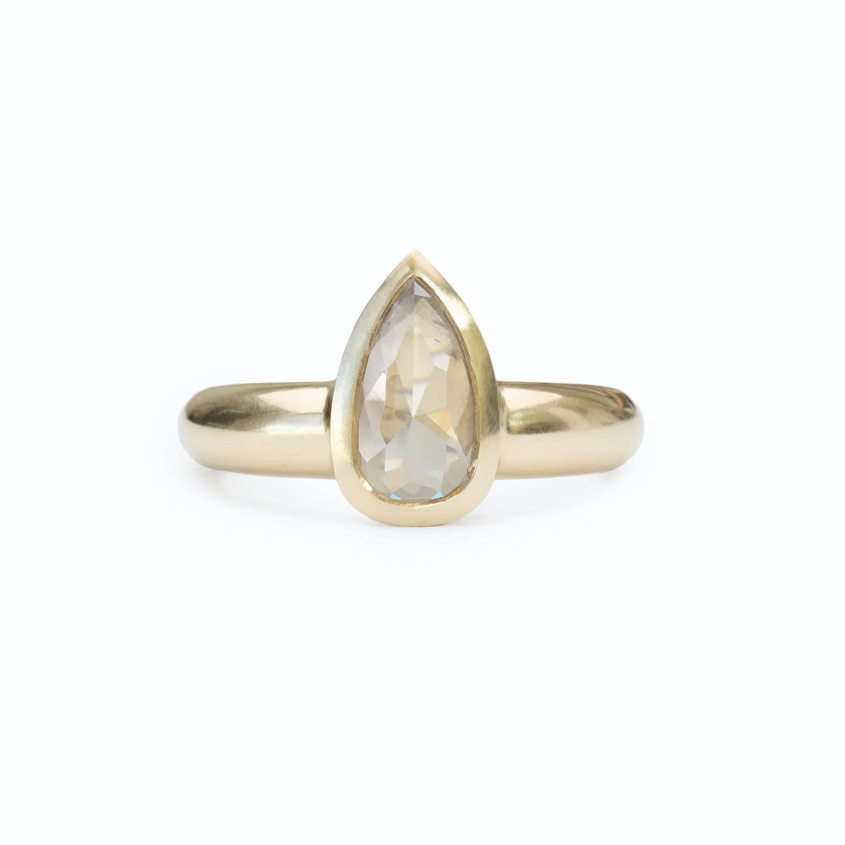 Elegant 14k yellow gold ring with bezel-set pear-shaped diamond on clean white background