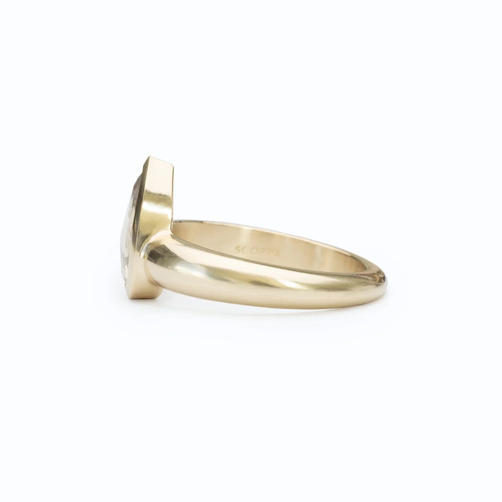 Side view of elegant 14k gold ring with faceted gemstone, polished finish on white background