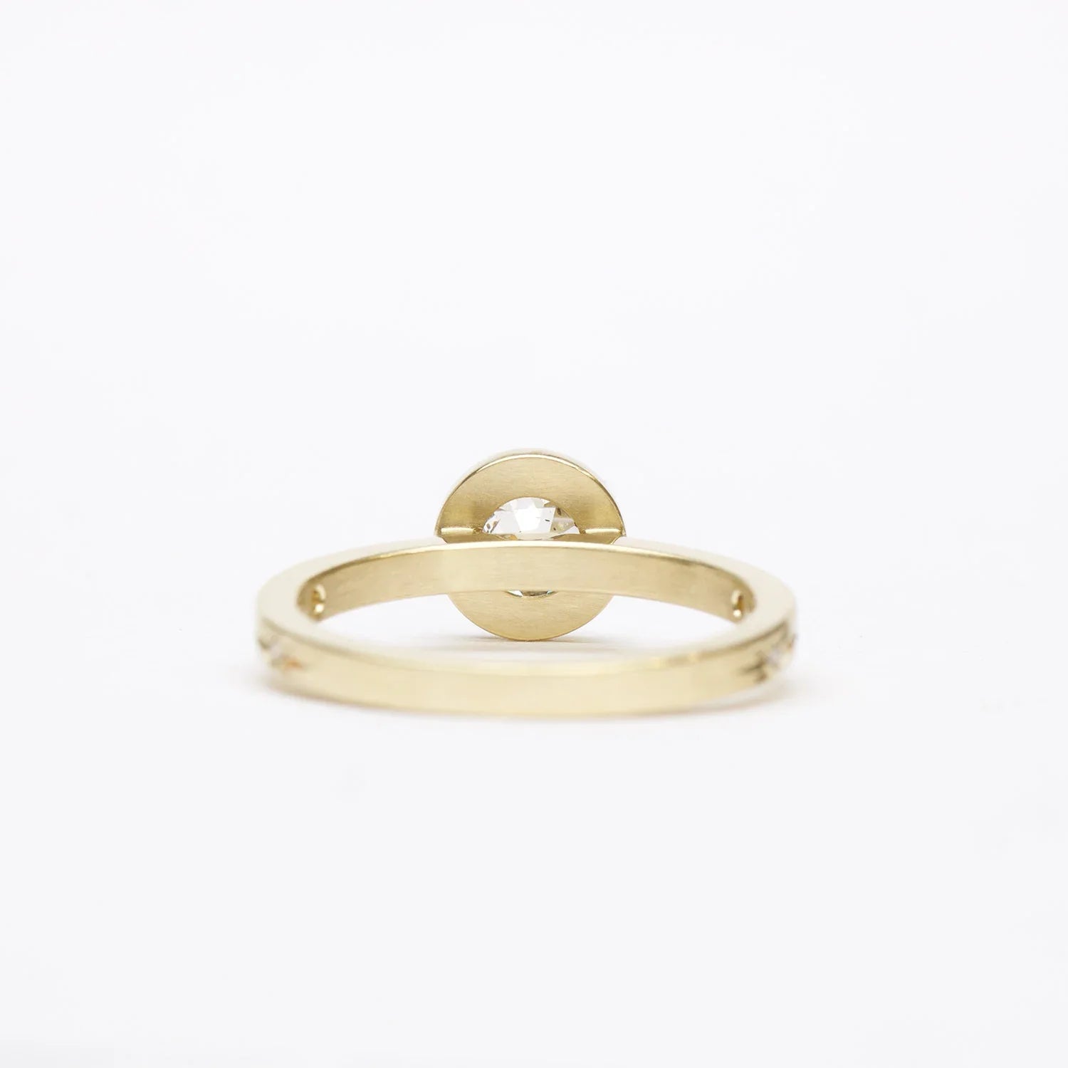 Handcrafted Fairmined gold ring with central gem, minimalist white background, soft natural light