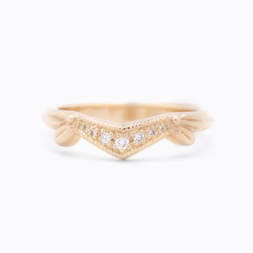 Delicate 14k gold ring with V shape setting and small sparkling diamonds on white background