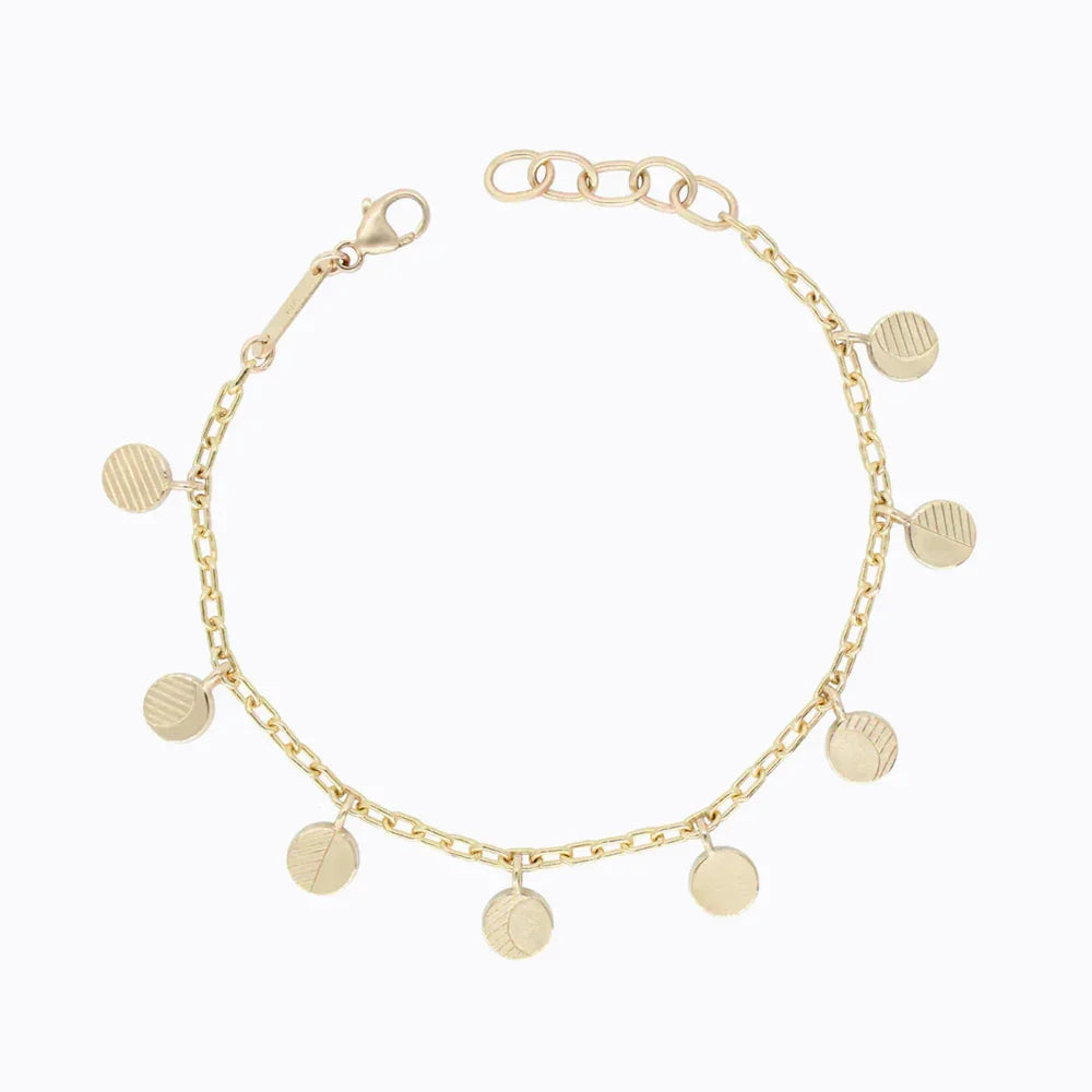 Refined gold chain bracelet featuring hand-textured round charms on clean white background