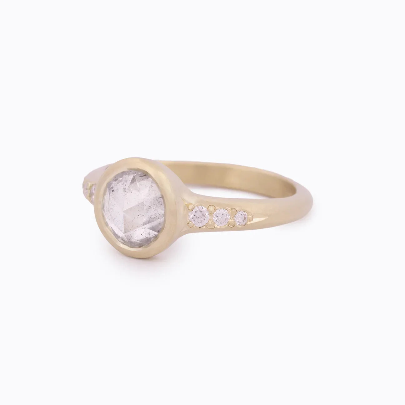 Handcrafted Fairmined gold ring with rose-cut diamond and small accent diamonds on soft white background