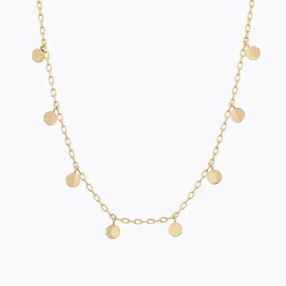 Delicate gold moon phase necklace with hand-engraved lunar charms on white background