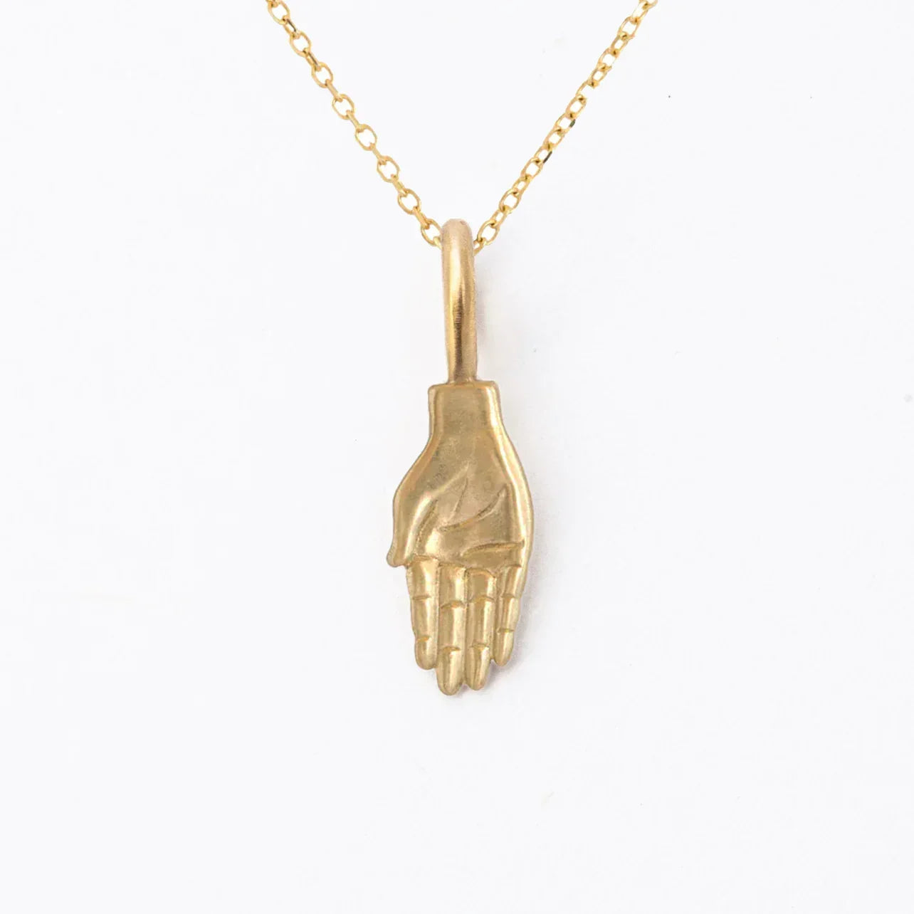 Hand-fabricated gold hand pendant necklace on clean white background with warm natural light