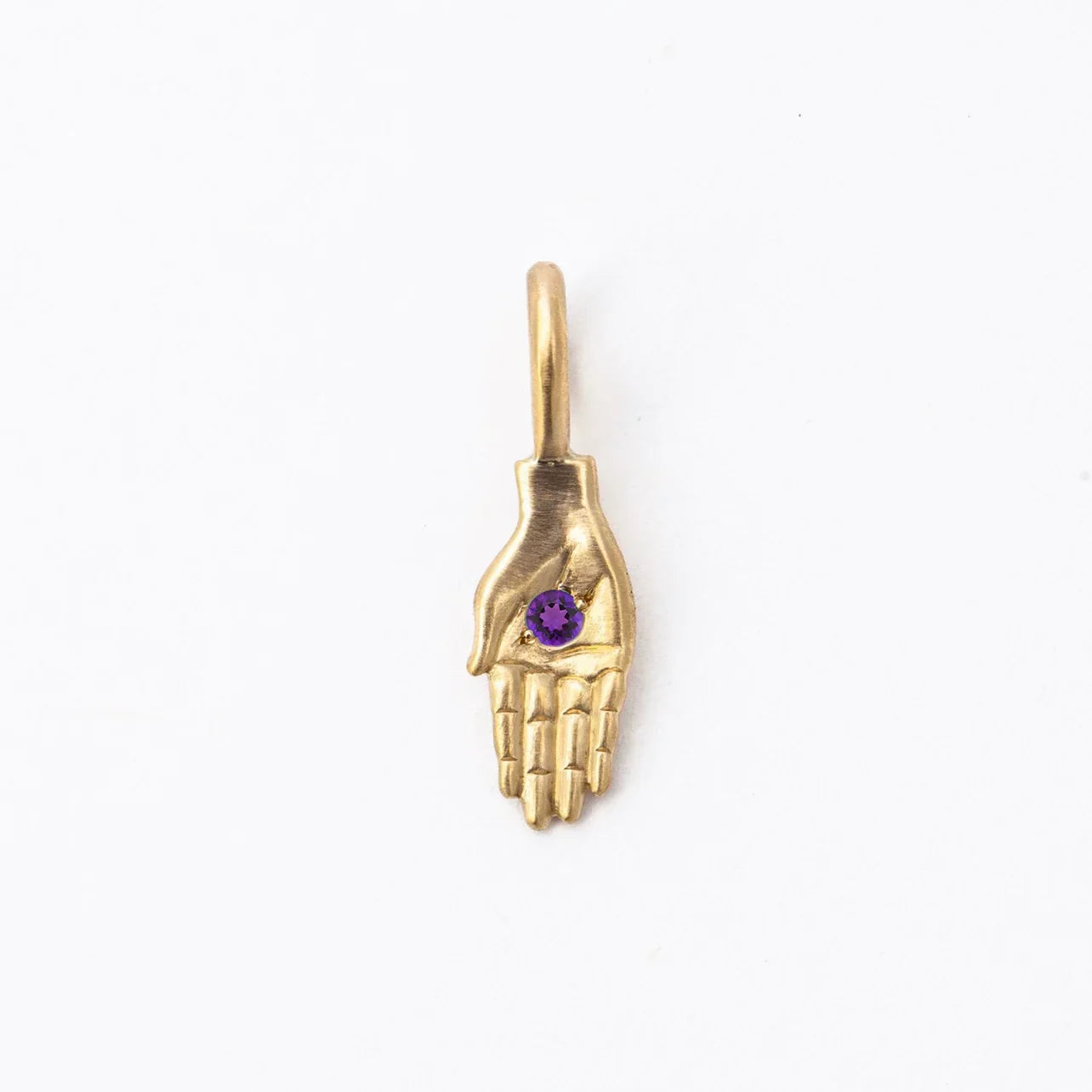 Handcrafted gold pendant shaped like a hand with a purple amethyst gemstone, photographed on clean white background