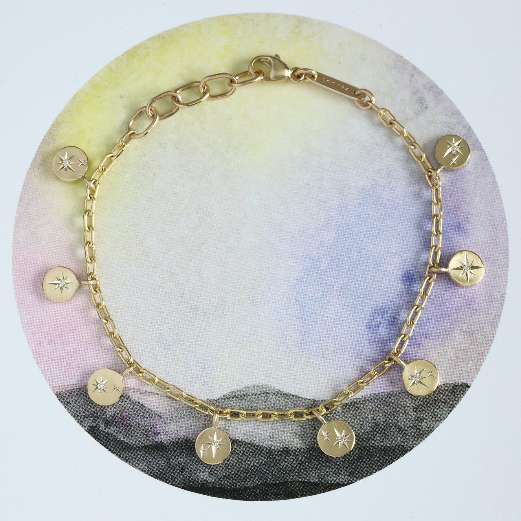 Hand-fabricated Fairmined gold chain bracelet with engraved starburst charms and diamonds on soft neutral circular background
