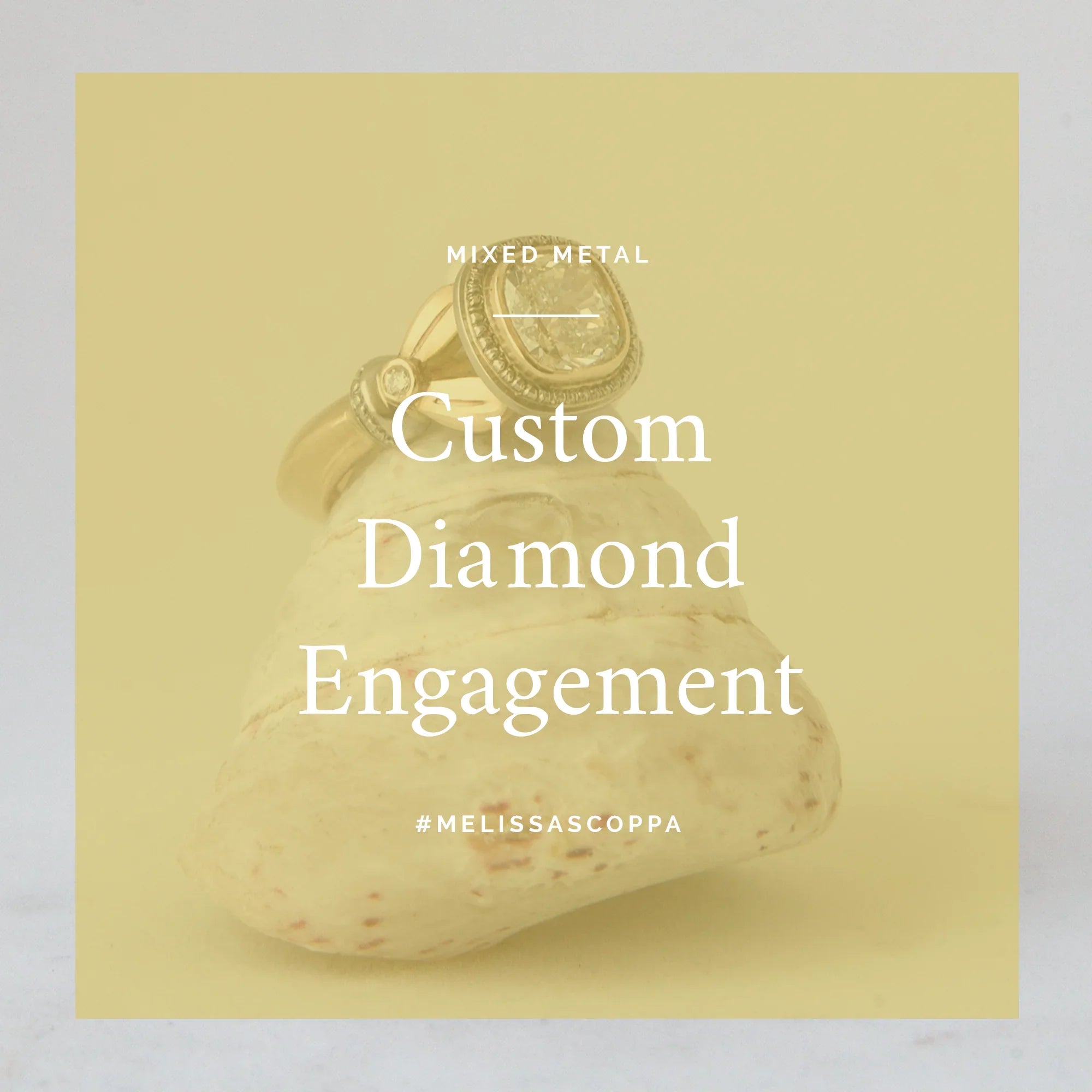 Custom diamond engagement ring with mixed metal design displayed on natural stone with soft neutral background