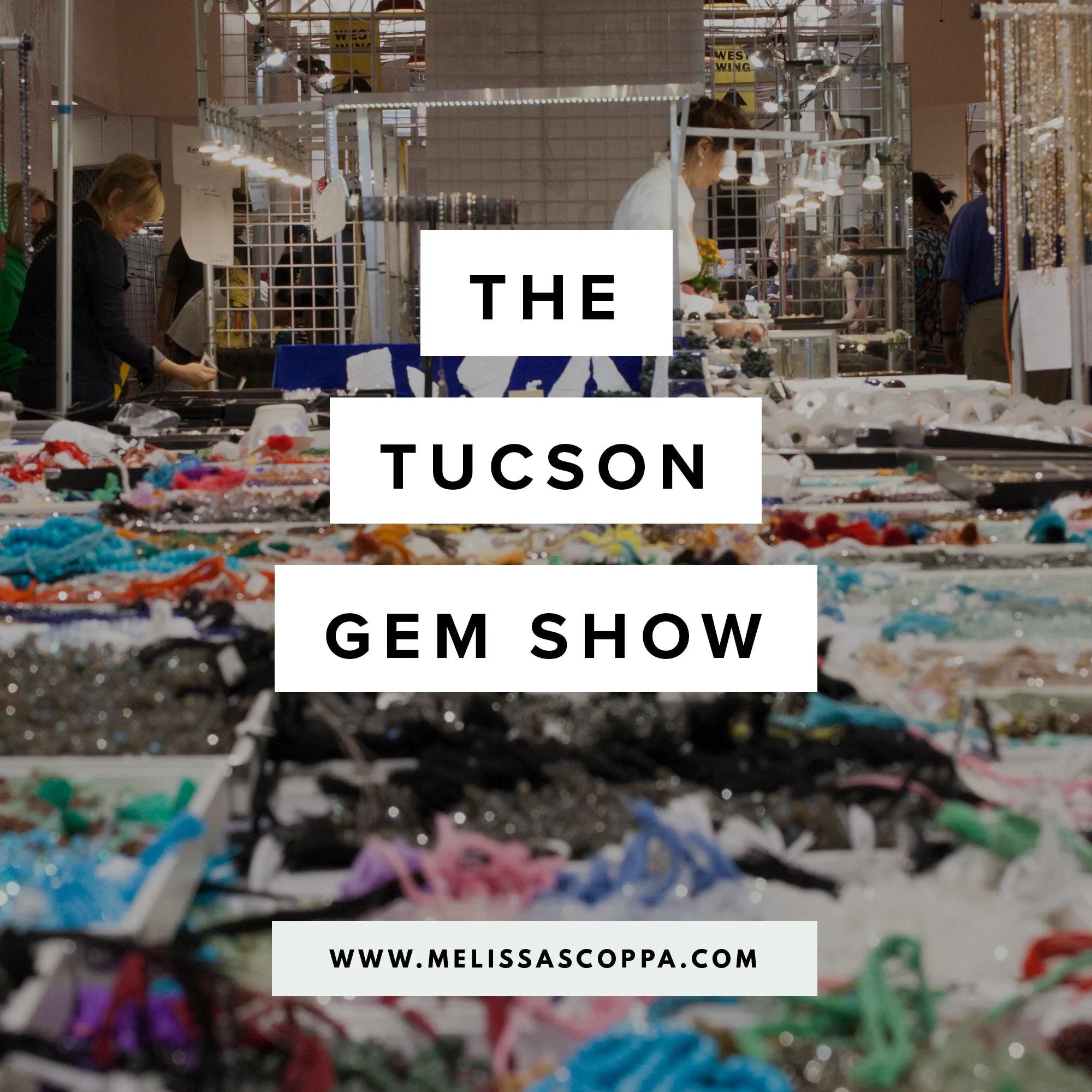Indoor view of Tucson Gem Show booths with jewelry displays and visitors browsing in warm natural light